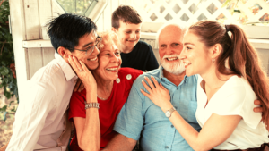 previdência privada mostra Casal de idoso recebendo carinhos de filhos e netos